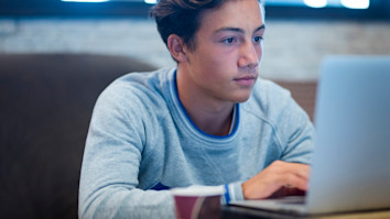 Portrait of teenager at home using his laptop for UCAS Hub