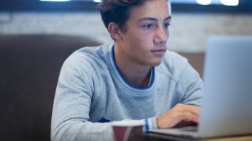 Portrait of teenager at home using his laptop for UCAS Hub