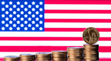 Graphic representing business in the USA, with several piles of American coins forming an ascending bar chart in front of the country's flag