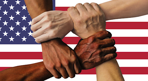 Four hands symbolise strength in unity by clenching each other's accompanying arms to form a square over the flag of the USA