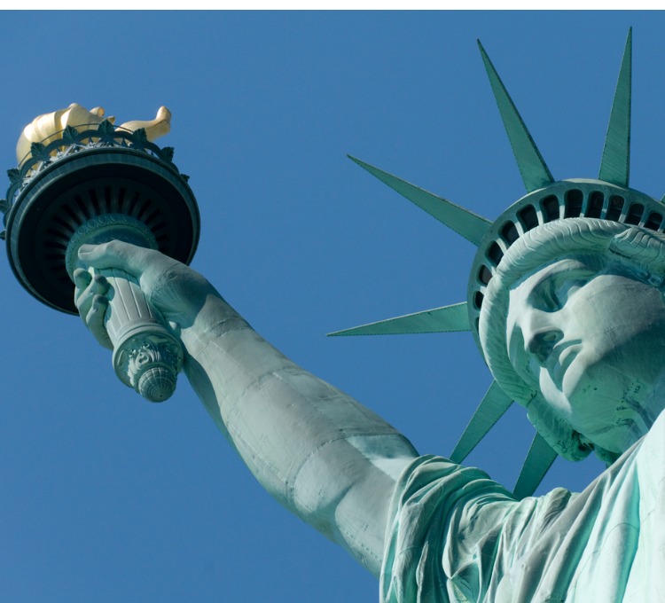 close up of statue of liberty head with torch on left hand side