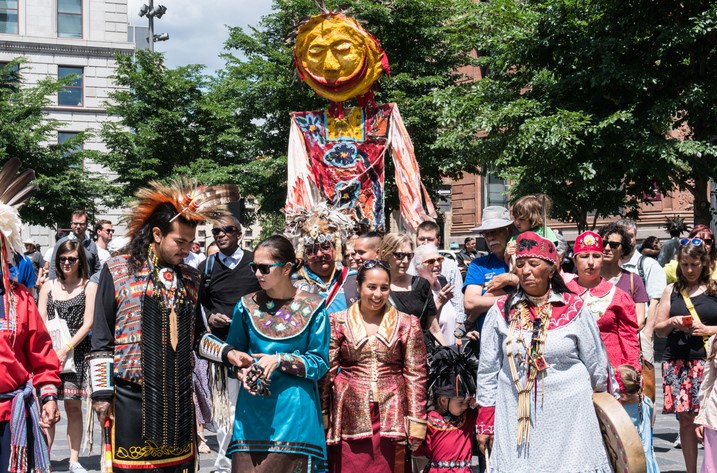 Dozens of Mohawk people carry an effigy and walk to the beat of a drum in Place d’Armes, Old Montreal.