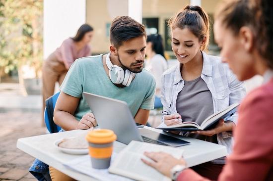 طلاب يقرأون تصنيف التايمز في الحرم الجامعي