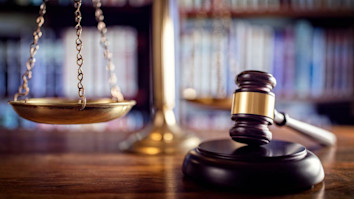 Judge gavel, scales of justice and law books in court