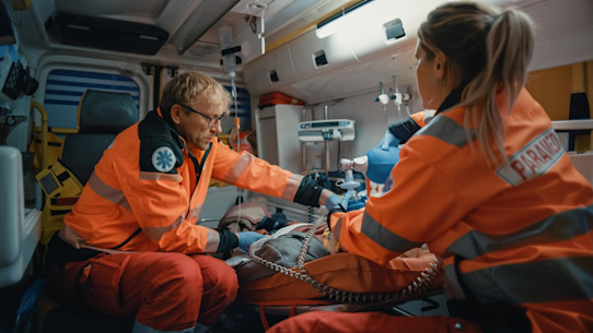 Paramedic team provides medical help to injured patient on the way to hospital