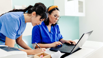 Female apprentice and nurse using the laptop in the hospital