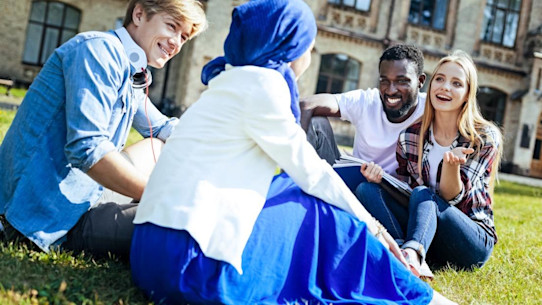 International university students sitting and socialising on the grass