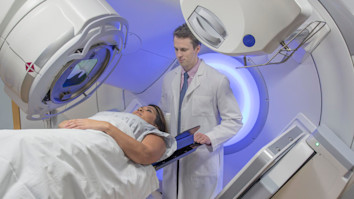 Doctor helping woman in scanner who is receiving radiation therapy treatment