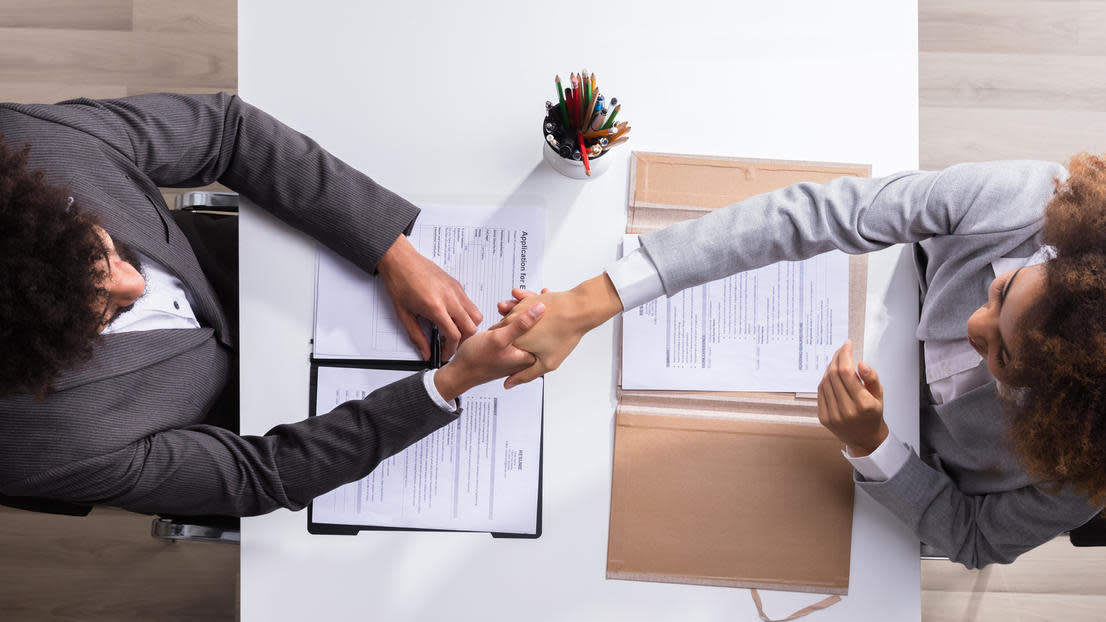 Two people shaking hands over business