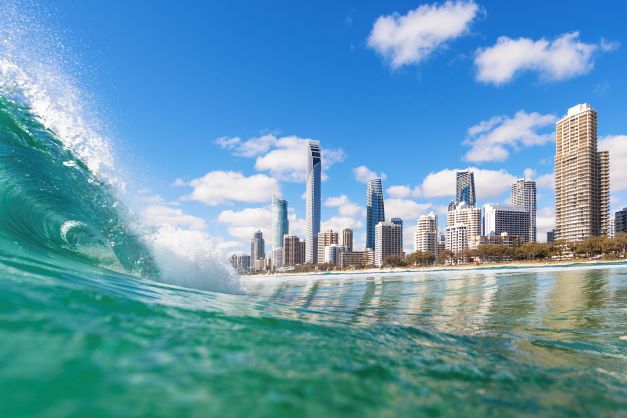 Foreground aqua blue wave rolling towards Gold Coast city view on the shore