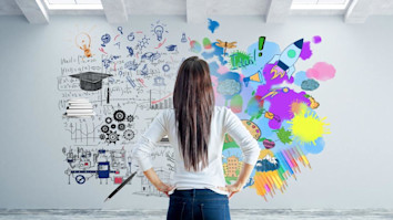 Young woman in concrete interior looking at wall with abstract sketch