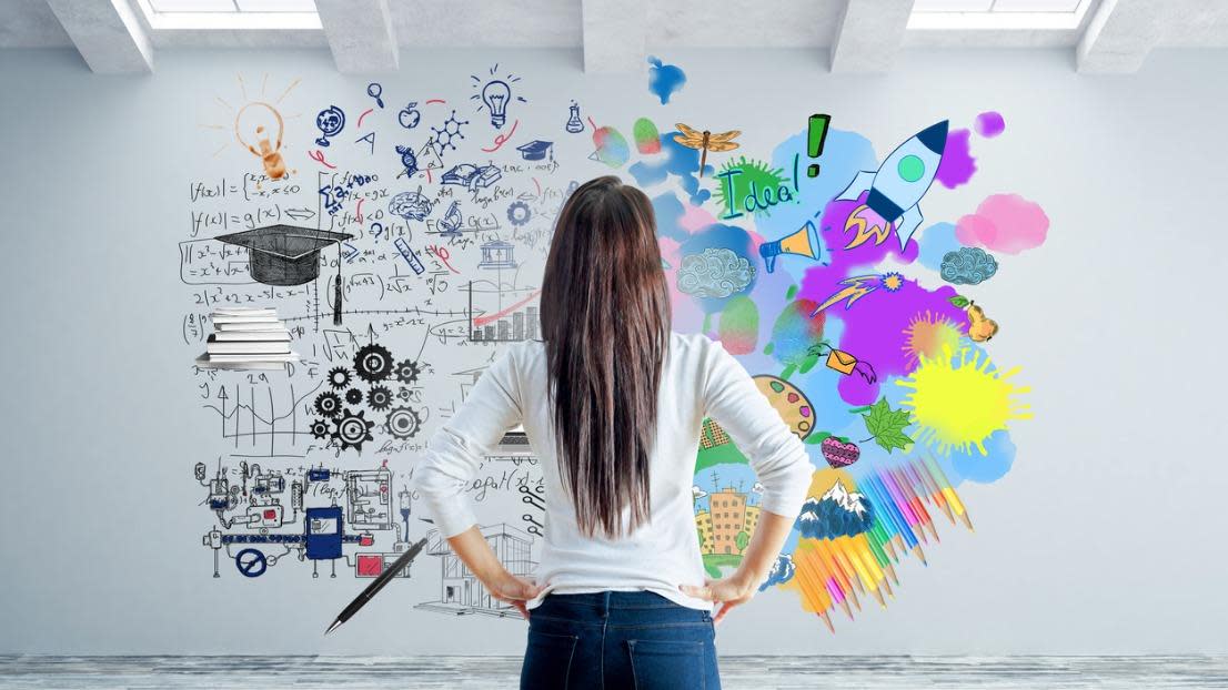 Young woman in concrete interior looking at wall with abstract sketch