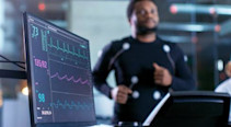 An athlete running on a treadmill with computers around him measuring his heart rate
