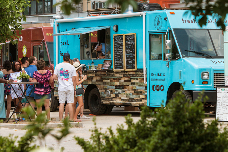 People wait in line and order from a food truck parked at the Old Fourth Ward Food Truck Festival on May 19, 2018 in Atlanta, GA.