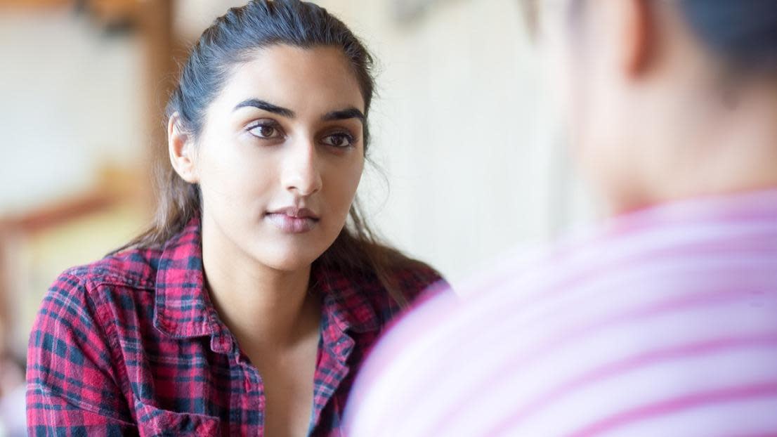 Serious young student discussing things with friend