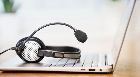 Laptop. Close up of headphones or headset on desk and plain background banner. 