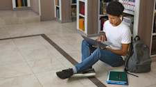 student sitting and look at laptop screen