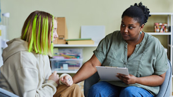 A social worker comforting a teenage girl