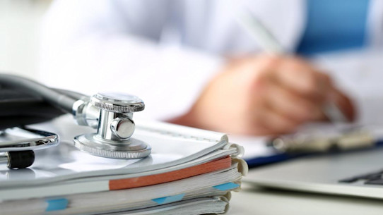 Stethoscope and medical forms on table