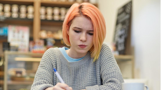 Young student makes notes in a notebook