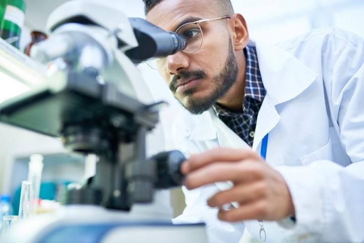 Medical student looking into a microscope