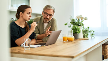 Father and daughter looking for UCAS Clearing courses on laptop