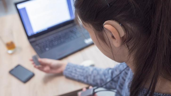 Student with clip-on hearing aid
