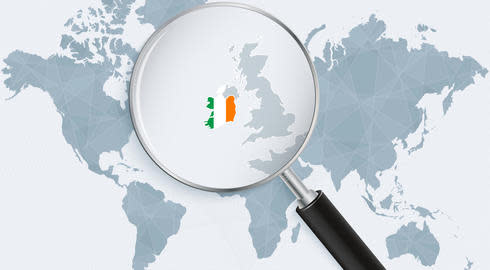A magnifying glass highlights Ireland on a map of the world. The country is coloured like its flag, in vertical stripes of green, white and gold.