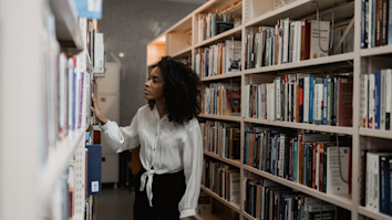 History graduate looking at books in library