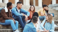 A group of students sitting on university steps on an open day