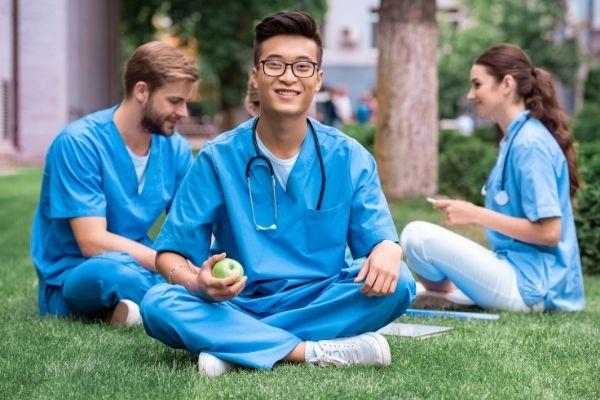 Mahasiswa jurusan kedokteran asal Indonesia sedang makan siang dan berdiskusi di taman dengan teman-teman kuliahnya di luar negeri