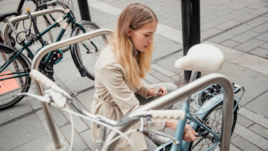 Student locking up her bicycle at the rack