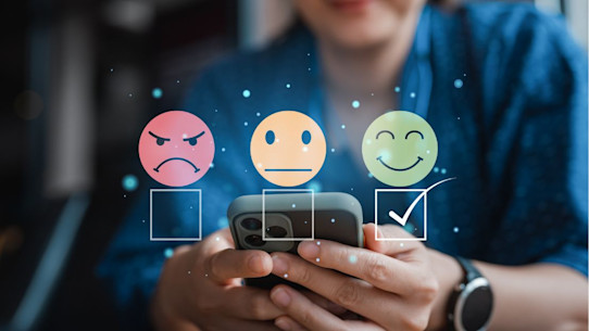 Student choosing a smiley face in an online survey on her smartphone