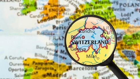 Map of Europe with a magnifying glass over Switzerland, showing the various countries it borders
