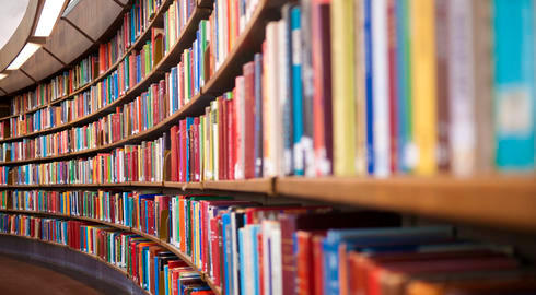 Library shelves filled with books of different colours.