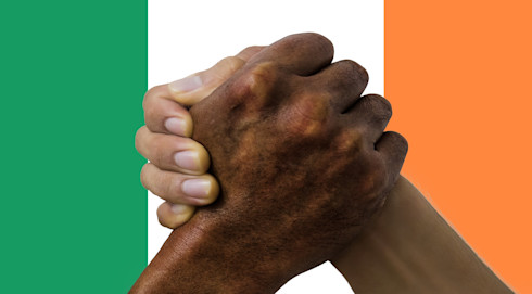 Two hands clench in front of the Ireland flag, representing unity and fellowship in Ireland
