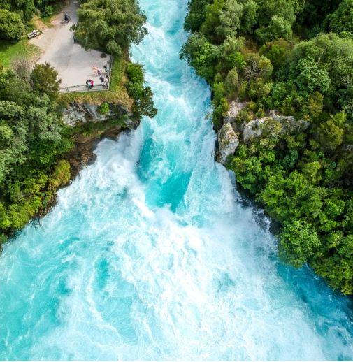 Alt text: Stunning aerial wide angle drone view of Huka Falls waterfall in Wairakei near Lake Taupo in New Zealand. 