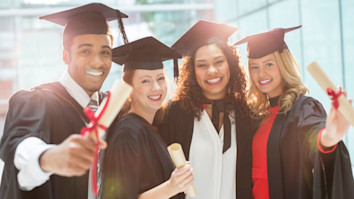 Graduates with their diplomas in caps and gowns