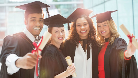 Graduates with their diplomas in caps and gowns