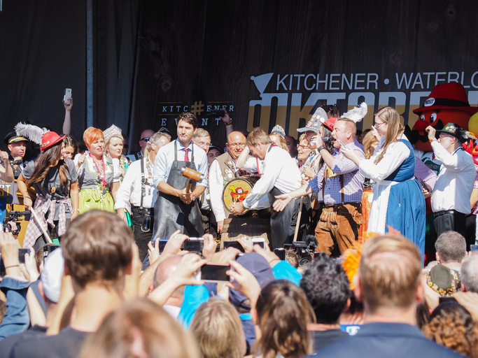 Justin Trudeau prepares to tap on a beer keg with a mallet as many happy people, some in Bavarian dress, surround him at Kitchener-Waterloo Oktoberfest.