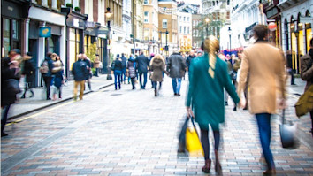Shoppers walking down the high street holding hands