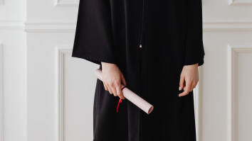 Student holding their degree at graduation