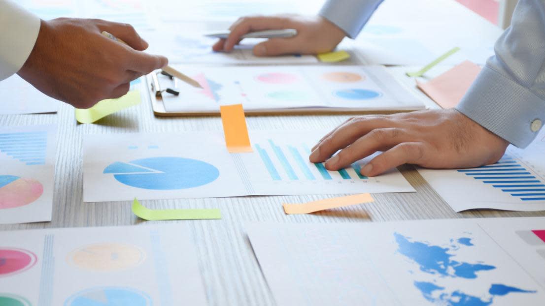 Two business people working on the office desk with graphs