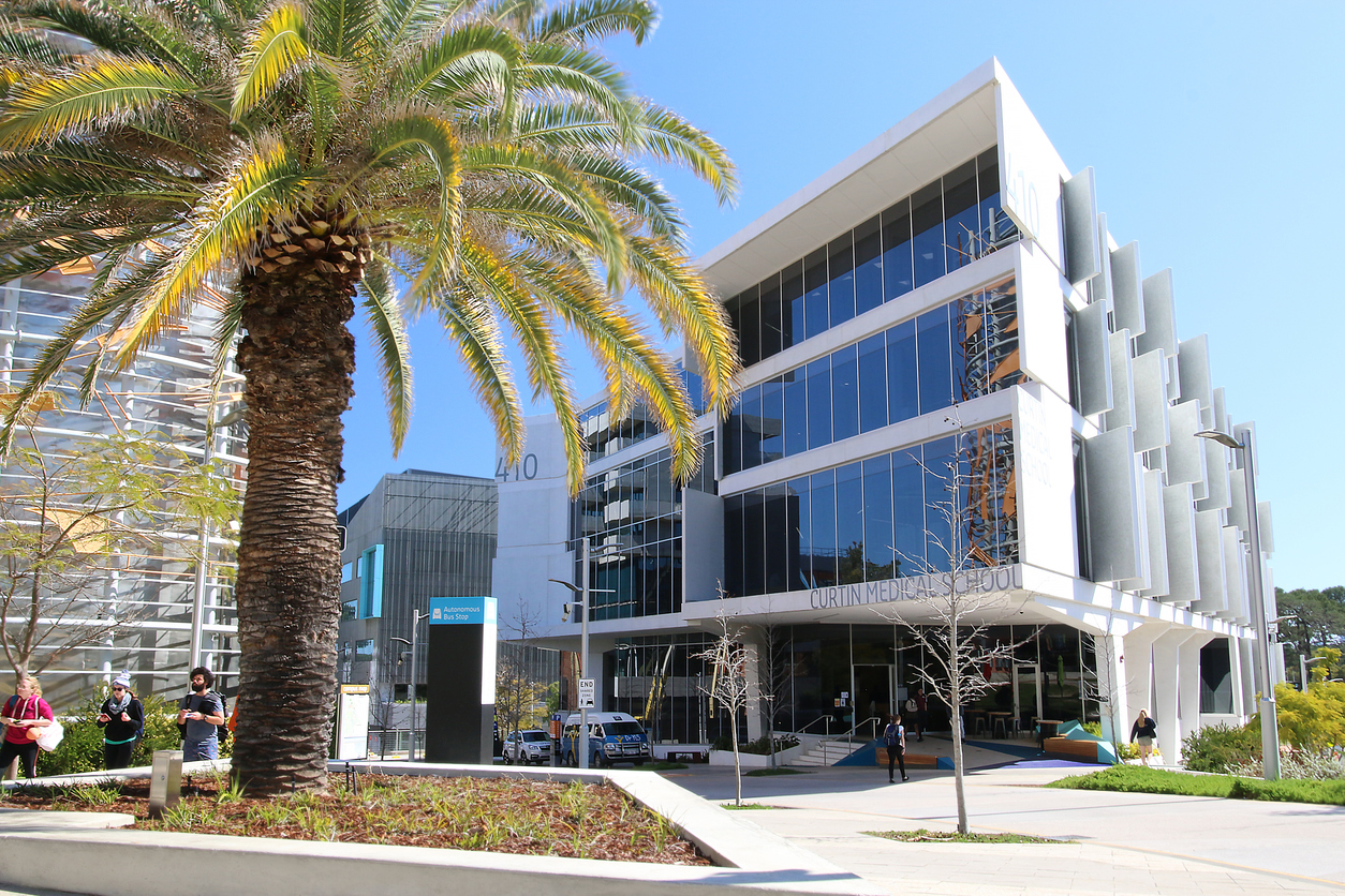 The glass-fronted exterior of Curtin University Medical School Building 410. The three-storey building has several large white panels extending from its side, and was a GHD project.