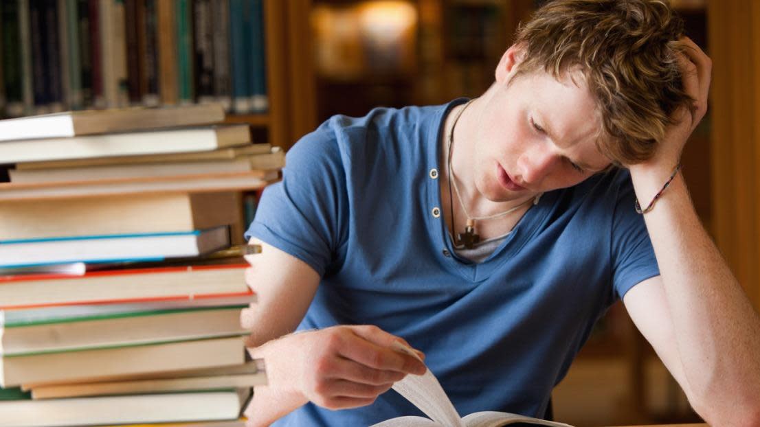 Tired student reading a book
