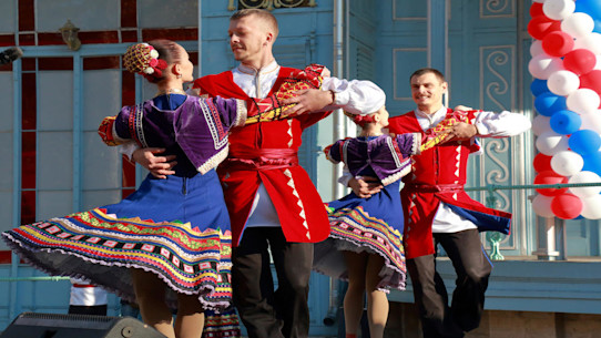 Two couple folk dancing on the stage in traditional dress in Pyatigorsk, Russia