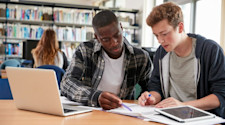 Two teenage boys revising in the library