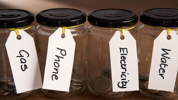 Coins in a jam jar with labels for budgeting
