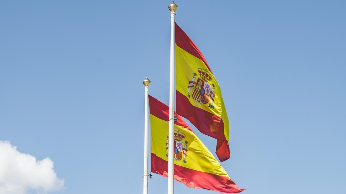 Two Spanish flags with a blue sky