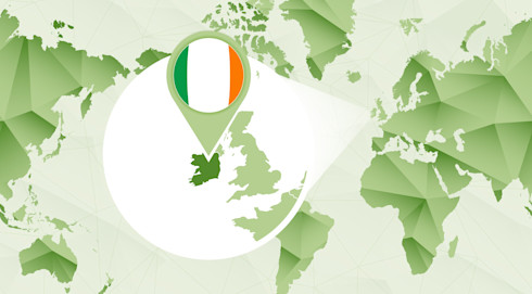 A pin coloured in the green, white and gold of the Irish flag identifies Ireland on a map of the world.